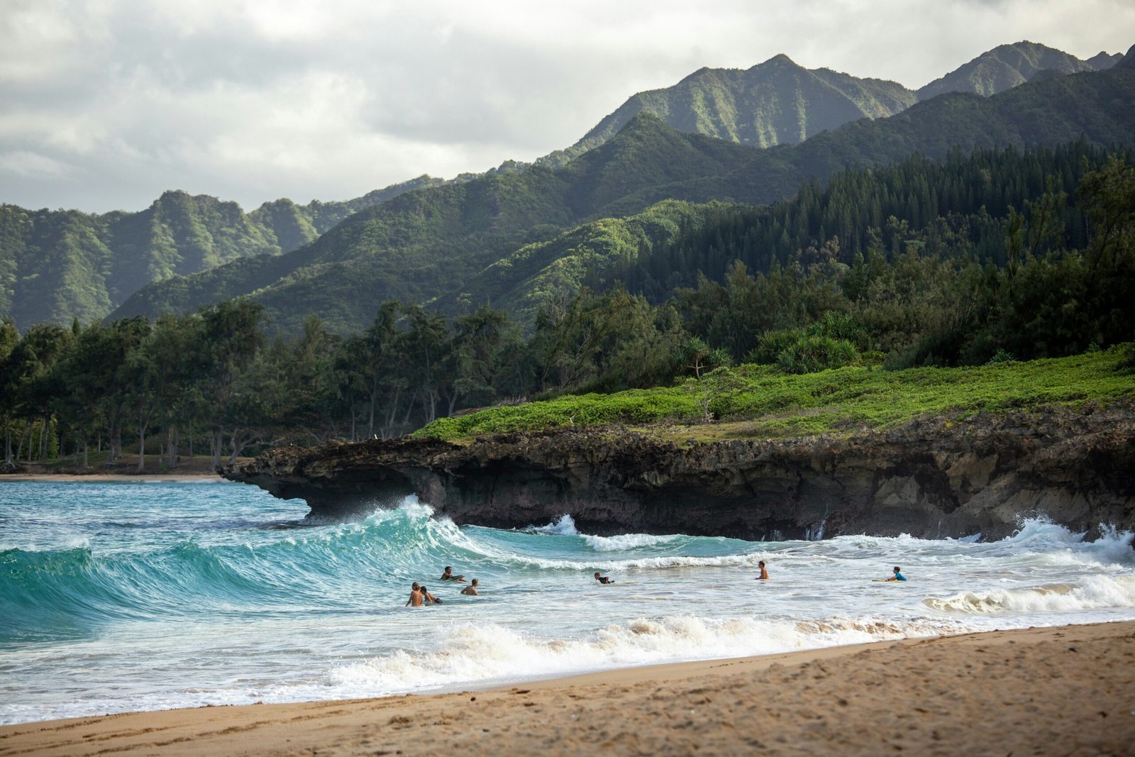 people swimming near shore with waves during daytime